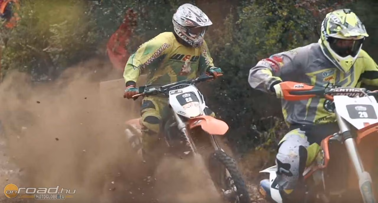 A mesterségesen nehezített terep mellett a test-test elleni küzdelem is komoly kihívás a versenyzőknek. A képen figyeljétek meg az éppen a hátsó motoros vállának repülő méretes követ!
